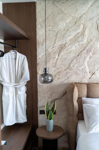 a bedroom with a white robe hanging on a wall at Athens Design Suites in Athens