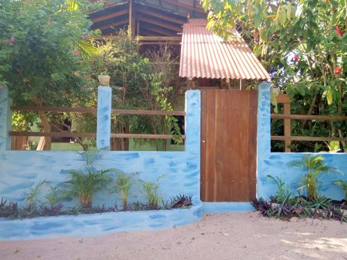 a blue fence with a wooden door and a gate at Mizu Spa & Hospedagem in Alter do Chao