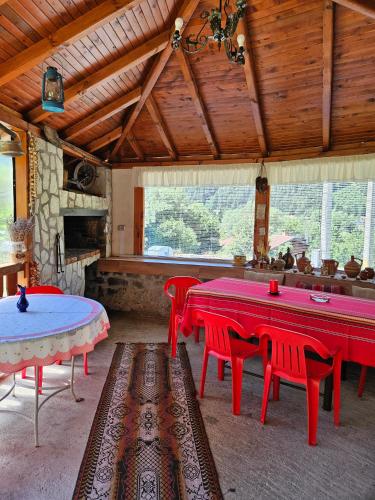 a room with red tables and chairs in a building at Юндовата къща in Beli Iskar