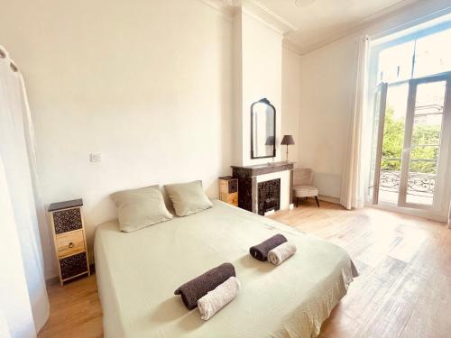 a white bedroom with a bed with two towels on it at NEMAUSA APARTIS in Nîmes