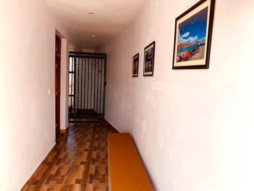 a hallway with a wooden bench on a wall at Milam Hostel in Leh