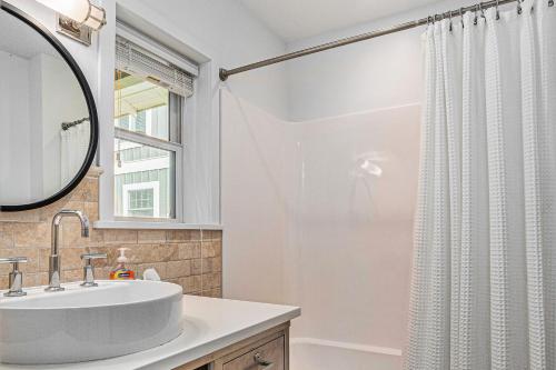 a bathroom with a sink and a shower curtain at Secluded Sunset in Glen Arbor