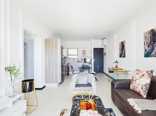 ein Wohnzimmer mit einem Sofa und einem Tisch in der Unterkunft Luxurious sandton apartment with Inverter in Sandton