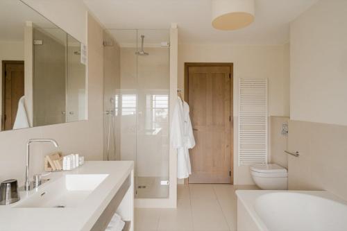 a bathroom with two sinks and a toilet and a shower at Aethos Corsica in Oletta