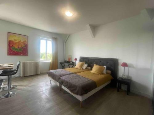 een slaapkamer met een bed, een tafel en een raam bij 1 Appartement en Bord de Loire {Maison Bardou} in Amboise