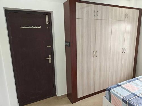 a bedroom with a brown door and two closets at Treva Pent House in Thirunallar