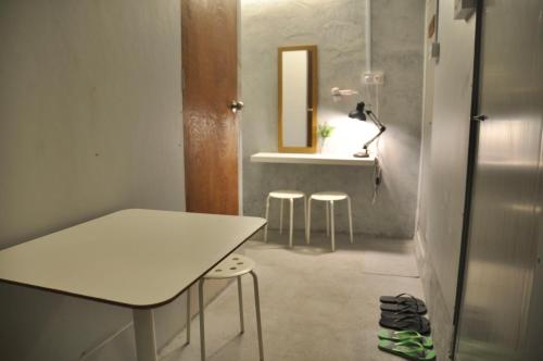 a room with a table and stools and a mirror at GRAYHAUS INN Ipoh in Ipoh