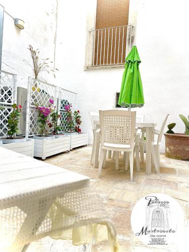 patio con tavolo e ombrellone verde di Palazzo Mastrovito a Martina Franca