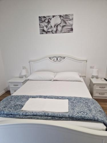 a bedroom with a white bed and two night stands at Appartamento Perla in Cologno Monzese
