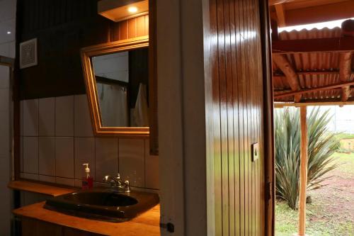 a bathroom with a sink and a mirror at Poas Volcano & La Paz Waterfall Cabins in Montaña Azul