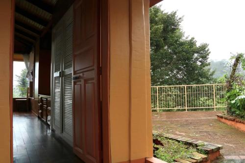 an open door of a house with a balcony at Poas Volcano & La Paz Waterfall Cabins in Montaña Azul
