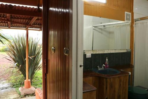 a bathroom with a sink and a mirror at Poas Volcano & La Paz Waterfall Cabins 