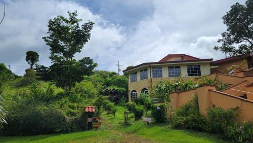 a house in the middle of a yard at Poas Volcano & La Paz Waterfall Cabins in Montaña Azul