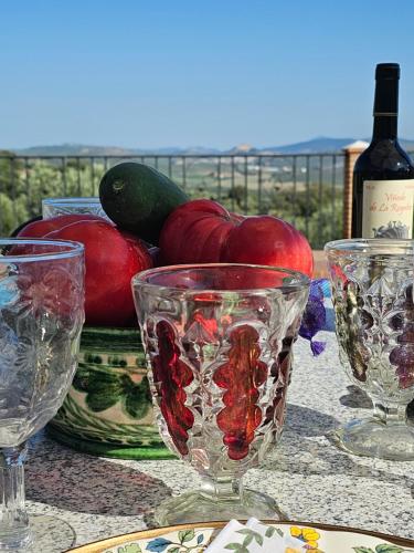 a table with three wine glasses and a bottle of wine at Villa San Nicolas - private, tranquil, relaxing.. in Ermita Nueva