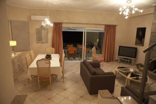 - un salon avec une table, un canapé et une télévision dans l'établissement VILLA DEEP BLUE, à Aghia Marina