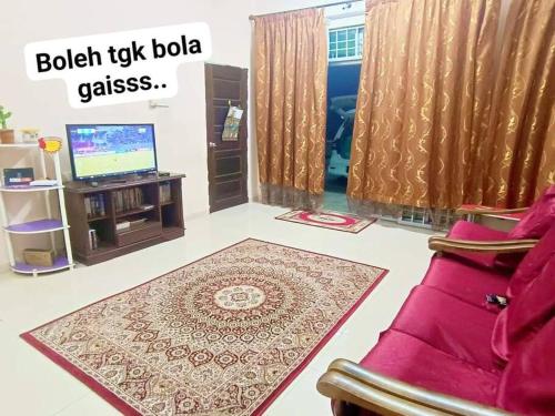 uma sala de estar com um sofá, uma televisão e um tapete em Hmsty D Hutan Kampung Alor Setar (Muslim) 