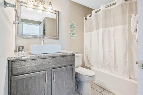 a bathroom with a sink and a toilet and a mirror at Ship Dock Lane B in Osage Beach