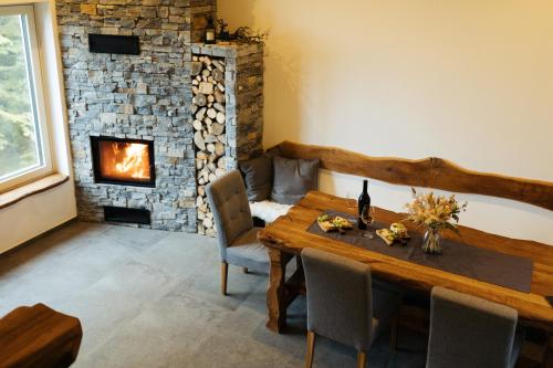 a dining room with a table and a fireplace at Alpine Cottage Golica in Jesenice
