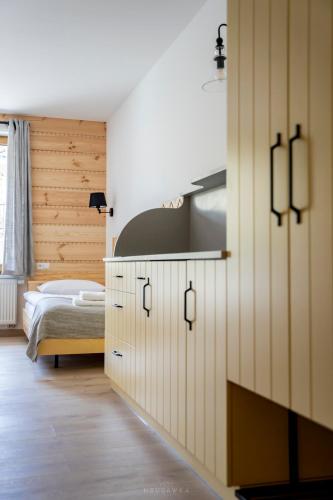 a bedroom with a bed and a kitchen with cabinets at Bella Monte in Szczyrk