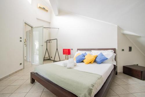 1 dormitorio con 1 cama con almohadas azules y amarillas en [Loft Eugenio] - *Large and bright apartment*, en Turín