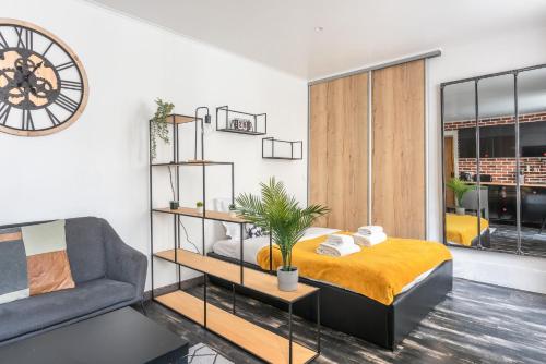 巴黎Design Studio near metro and Eiffel Tower的卧室里有一张床，墙上挂着一个钟
