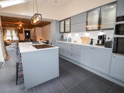a kitchen with white cabinets and a large island at Glan William in Dolwyddelan