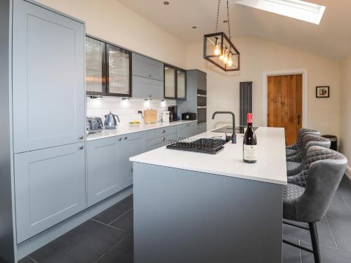 a kitchen with white cabinets and a counter top at Glan William in Dolwyddelan