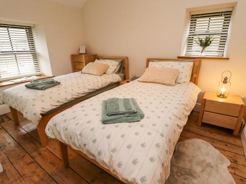 two twin beds in a room with two windows at Glan William in Dolwyddelan