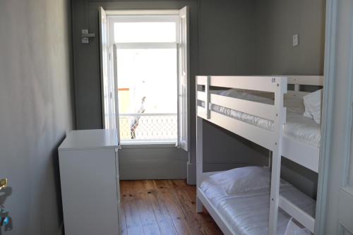 a bedroom with a bunk bed and a window at A Beira Hostel in Aveiro