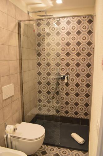 a small bathroom with a toilet and a shower at TANIT ROOMS & SPA in Villasimius