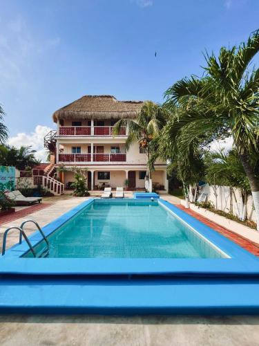 a swimming pool in front of a house at Hotel El Perico Marinero in Río Lagartos