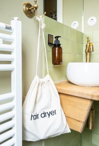 a white bag hanging on a bathroom sink at Boutique-Hotel Stadtherberge Wetzlar in Wetzlar