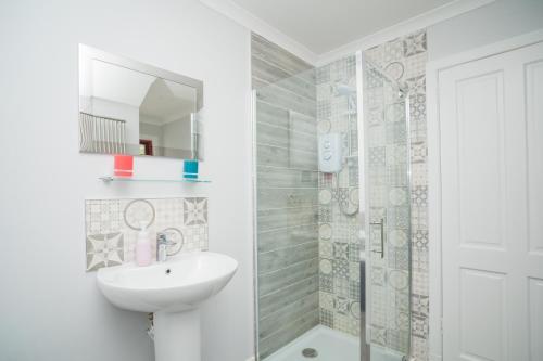 biała łazienka z umywalką i prysznicem w obiekcie Tig Cottage - a rural, quirky, pet friendly 2 bedroom cottage near Ballantrae w mieście Ballantrae