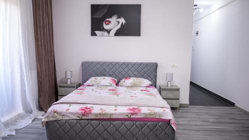 1 dormitorio con 1 cama con manta y almohadas en Nina House, en Târgu Jiu