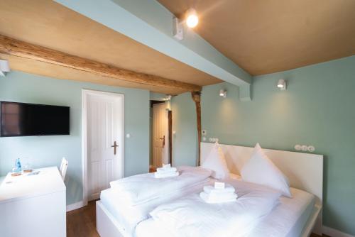 a bedroom with a bed with white sheets and pillows at Boutique-Hotel Stadtherberge Wetzlar in Wetzlar