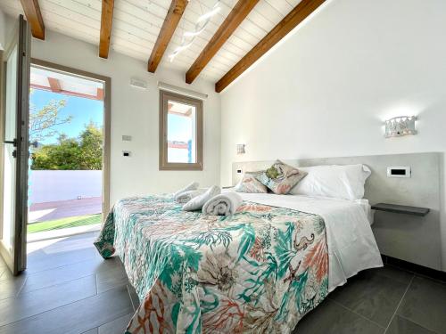 um quarto com uma cama grande e uma janela grande em Country & Beach Suites em Cardedu
