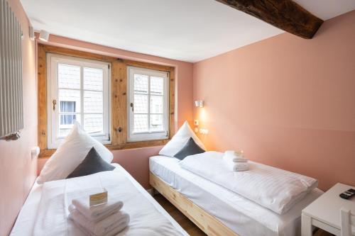 two beds in a room with two windows at Boutique-Hotel Stadtherberge Wetzlar in Wetzlar