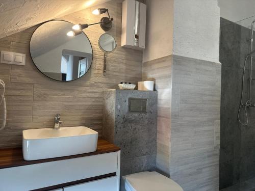 W łazience znajduje się umywalka i lustro. w obiekcie Pensjonat Pod Wozem w mieście Trzebiatów