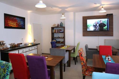 un restaurante con mesas y sillas y TV en la pared en Arthotel, en Bad Pyrmont