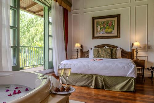 a bedroom with a bed and a bath tub and a tub at Hotel Casa Turire in Turrialba