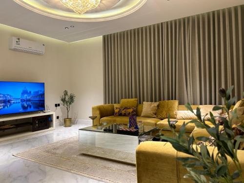 ein Wohnzimmer mit einem Sofa und einem TV in der Unterkunft شقة فاخرة ٣ غرف وصالة ٣ in Riad