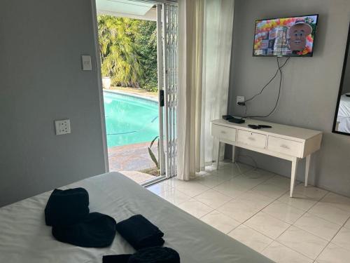 a bedroom with a bed and a desk and a pool at Decent Stay in Durban