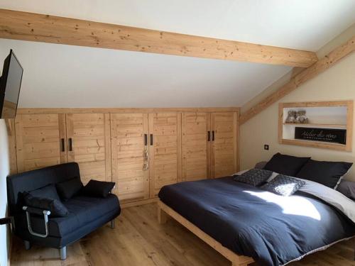 a bedroom with a bed and a couch at GITE La fromagerie Haut Jura in La Mouille