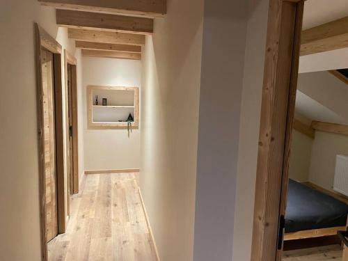 an empty room with a bed and wooden floors at GITE La fromagerie Haut Jura in La Mouille
