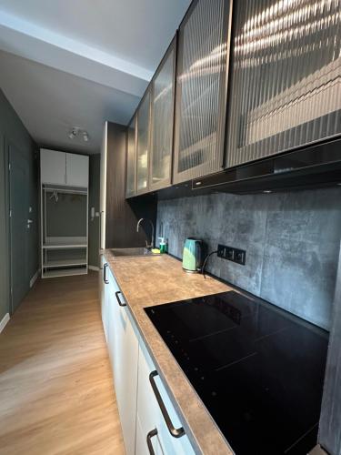 a kitchen with white cabinets and a black counter top at MISVEST Tomasz Klimatyzacja in Zabrze