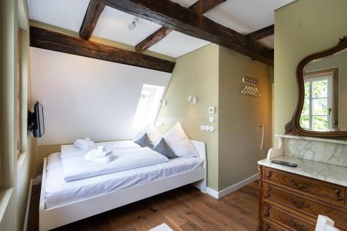 a bedroom with a bed and a window and a mirror at Boutique-Hotel Stadtherberge Wetzlar in Wetzlar