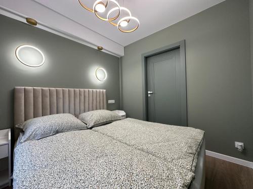 a bedroom with a bed and a chandelier at MISVEST Tomasz Klimatyzacja in Zabrze