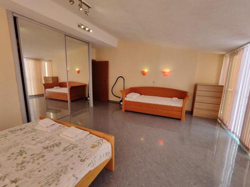 a large room with two beds and a mirror at Apartment Crocus of Rafailovici in Budva