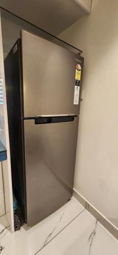 a stainless steel refrigerator sitting in a kitchen at 1BHK Serviced Apartment – Palayam in Trivandrum