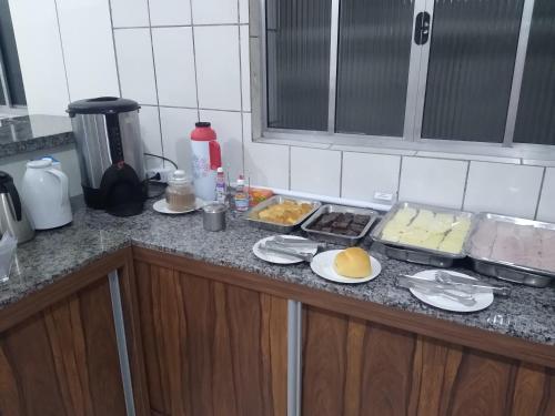 a kitchen counter with plates of food on it at HOTEL MORADA DO SOL in Pontal do Paraná